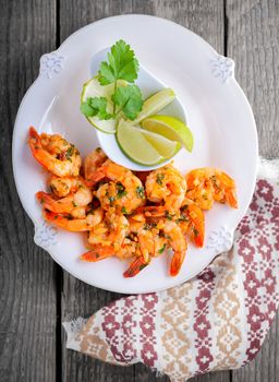 Fried Prawns with lemon served on a wooden surface