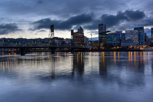 Portland Oregon downtown city skylinw by Hawthorne Bridge along Willamette River at evening blue hour