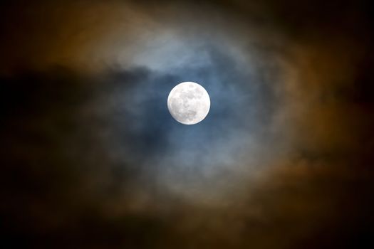 Fast moving storm clouds breaking for the full moon