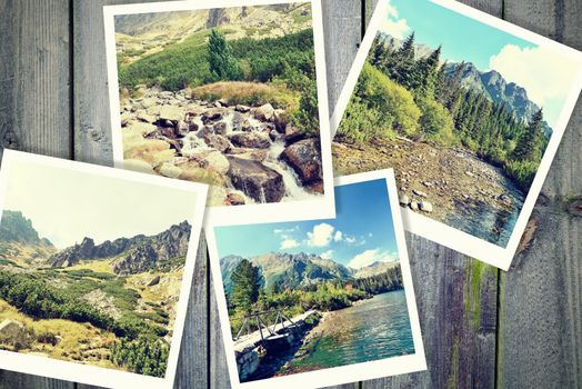 Heap of the vintage photos from holiday in mountains with traditional white frame placed on wooden desk.