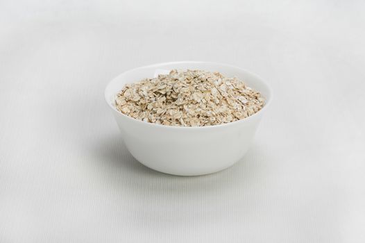 Bowl of oats porridge isolated on a white background Healthy breakfast