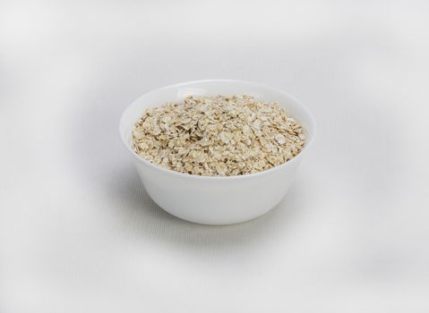 Bowl of oats porridge isolated on a white background Healthy breakfast