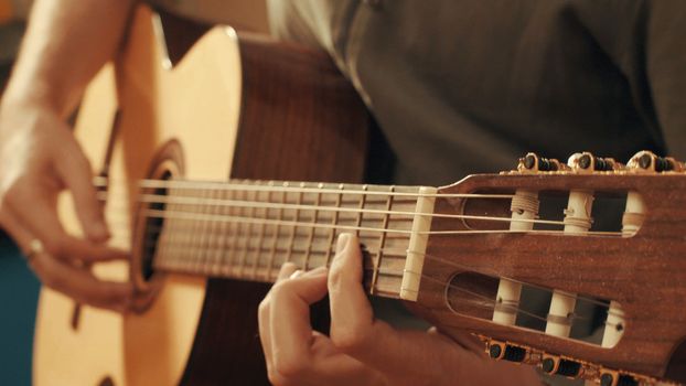 Hands of guitarist playing a guitar. Close up