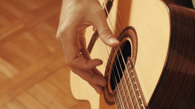 Hands of guitarist playing a guitar. Close up