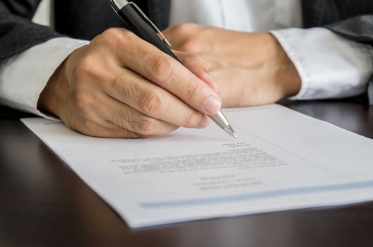 Close-up Businessman or job seeker signing on resume form.