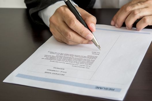 Close-up Businessman or job seeker signing on resume form.