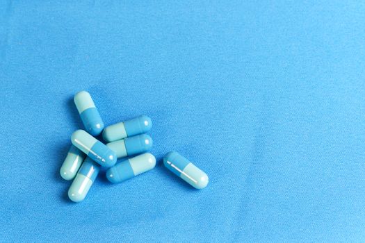 medicine and substance abuse concept treatment in capsules on clean blue cloth