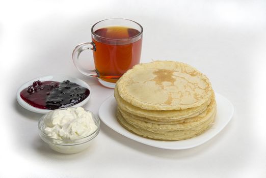 pancakes with jam and milk smeranoy on a wooden plank