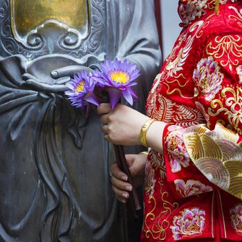 Woman hand respect to buddha statue.