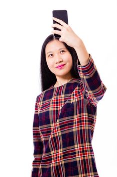 Chinese teenage girl in plaid dress taking selfie with smartphone