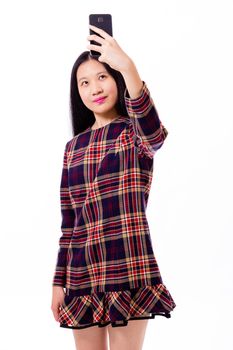 Chinese teenage girl in plaid dress taking selfie with smartphone