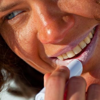 Close up of the nice girl, applicating the sunblock cosmetics.