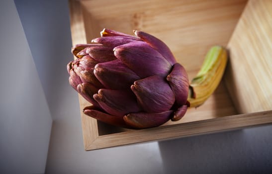 Fresh Artichoke in a square wooden plate