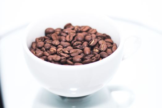 White cup with coffee beans inside