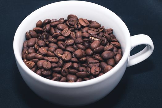 White cup with coffee beans inside