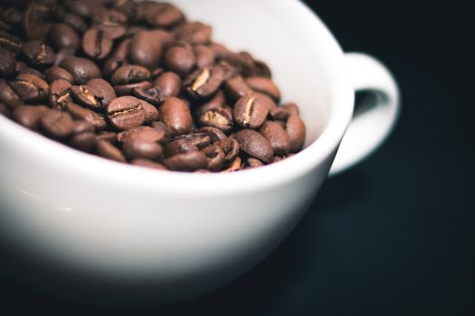 White cup with coffee beans inside