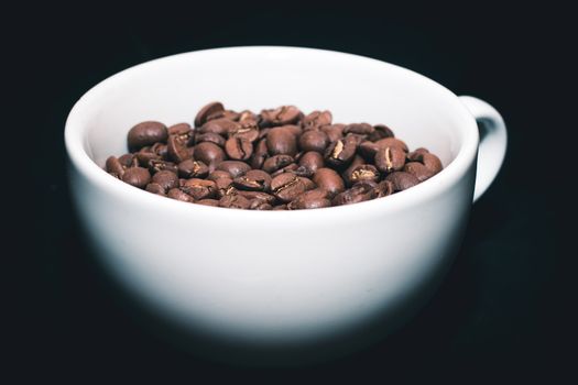 White cup with coffee beans inside