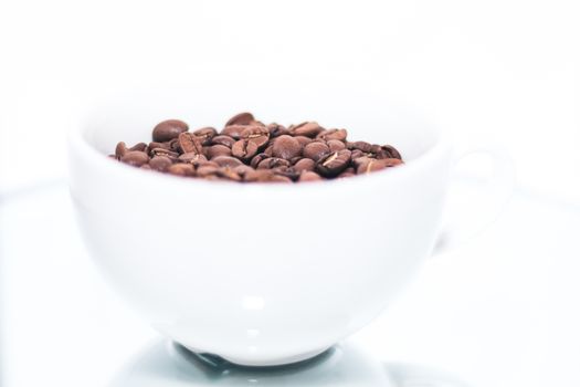 White cup with coffee beans inside