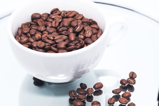 White cup with coffee beans inside