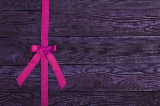 Grunge plank wood texture background with pink ribbon