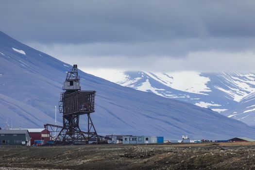 Beautiful scenic view of blue gulf under barren mountain range with melting snow against the background of dramatic evening sky near Barentsburg, Spitsbergen (Svalbard island), Norway, Greenland sea

