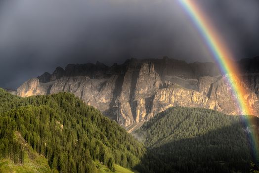 Rainbow after the thunderstorm over the hills and mountains of Selva di Val Gardena in a summer end of the day, Trentino-Alto Adige - Italy