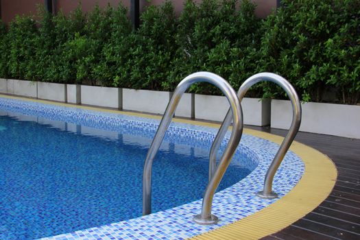 Grab bars ladder in blue swimming pool