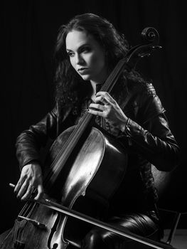 Photo of a beautiful female musician playing a cello.