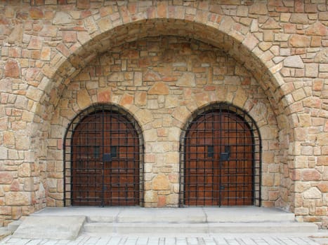 Double-arched stone temple entrance closed iron bars.