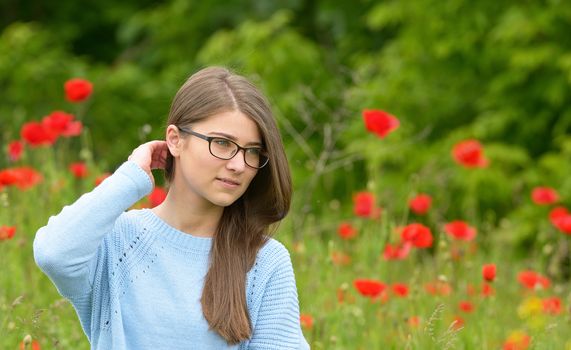 Beautiful young girl in the poppy field