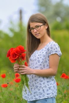 Beautiful young girl in the poppy field