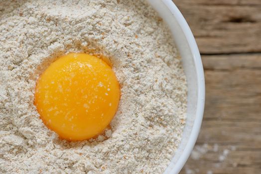 Flour and eggs ready for mixing on wooden table