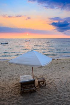 Sunset over Madagascar Nosy be beach with sunlounger and parasol. Africa vacation travel concept.