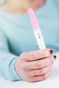 Young woman holding a Pregnancy Test in her hands