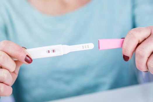 woman holding a Pregnancy Test pregnancy test positive result in her hands