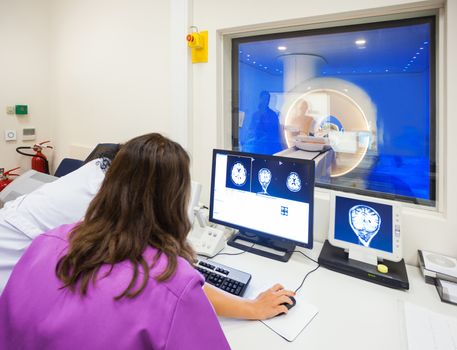 Operators are looking at images of MRI scanned human brain in modern hospital.