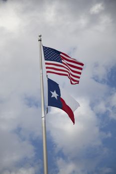 United States and Texas state flags billowing in the wind