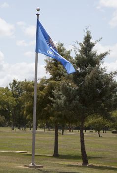 Oklahoma state flag waving against a blue sky