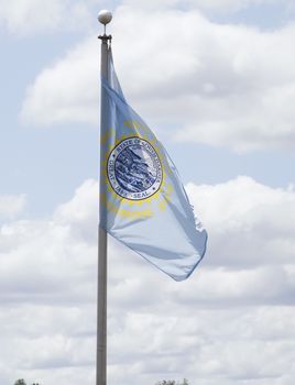 South Dakota state flag waving in blue sky