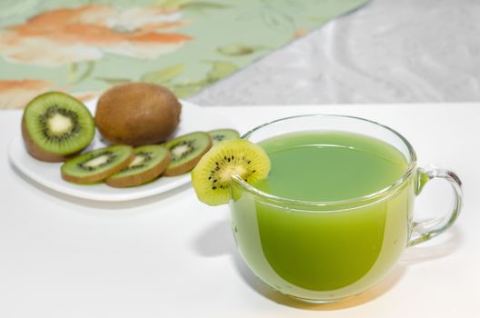 Fresh kiwi juice in a Cup and fruits on the plate. Selective focus, space for text.