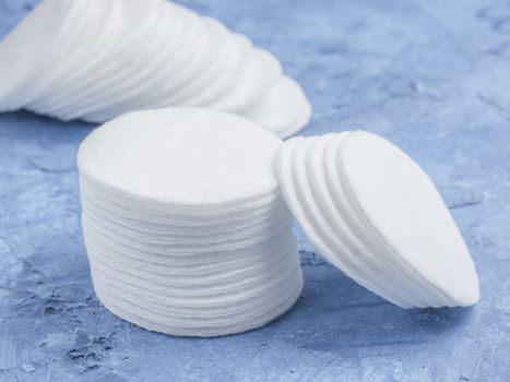 cotton pads on blue concrete background close up