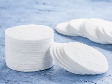 cotton pads on blue concrete background close up