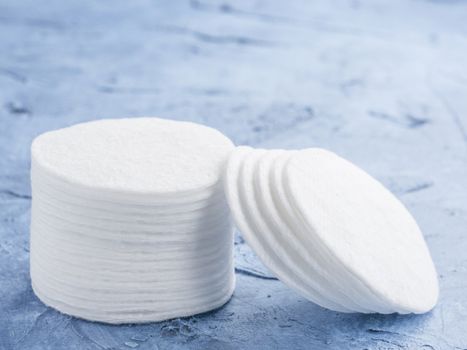 cotton pads on blue concrete background close up