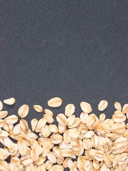 raw oatmeal on gray background with copy space. Isolated one edge. Top view or flat lay.