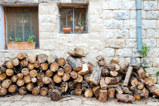 Firewood for the stove piled against the wall near the kitchen in the courtyard of an old house