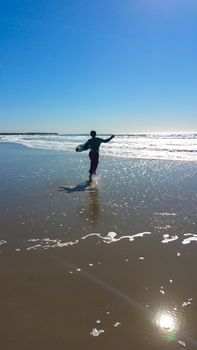 Young Girl Running to the Waves at the Beach