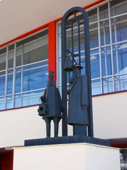 statue of metal on the facade of a large building