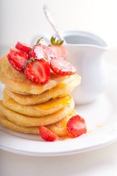 Stack of sweet pancakes with strawberry and honey. Gluten free flour.