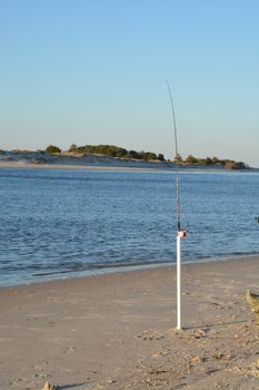 A view of the shore around the north end of Carolina Beach with a fishing pole suck in the ground.