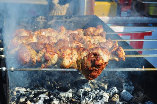 Meat is fried on skewers over charcoal on the grill